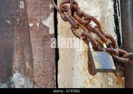 Detail of old, rusty padlock and metal chain. Space in left Stock Photo