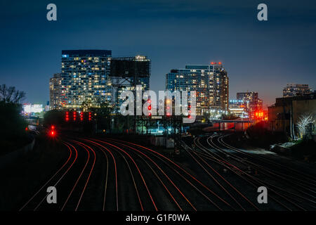 View of a rail yard and modern buildings at night, from the Bathurst Street Bridge in Toronto, Ontario. Stock Photo