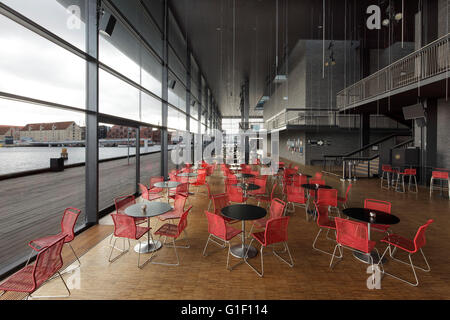 Foyer with red seating and harbour through panoramic windows. Royal Danish Playhouse, Copenhagen, Denmark. Architect: Lundgaard Stock Photo