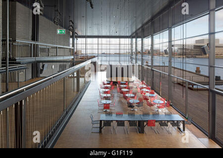 Foyer with red seating and harbour through panoramic windows. Royal Danish Playhouse, Copenhagen, Denmark. Architect: Lundgaard Stock Photo