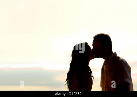 silhouette of a young couple kissing at sunset Stock Photo - Alamy