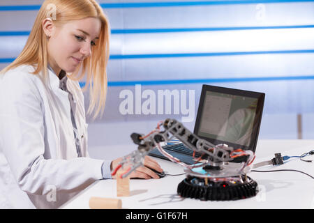 MODEL RELEASED. Female electrical engineer working in lab with computer. Stock Photo