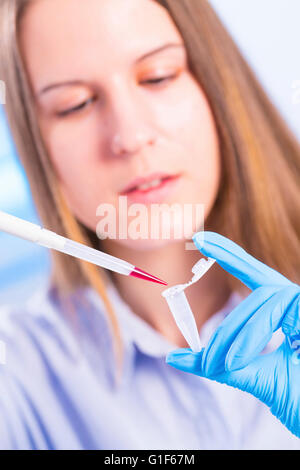 MODEL RELEASED. Female lab technician using pipette and eppendorf tube. Stock Photo