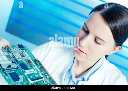 MODEL RELEASED. Female electrical engineer holding circuit board. Stock Photo