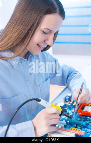 MODEL RELEASED. Female electrical engineer working on circuit board. Stock Photo