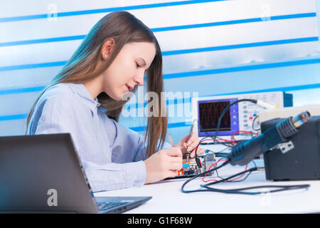 MODEL RELEASED. Female electrical engineer working on circuit board. Stock Photo