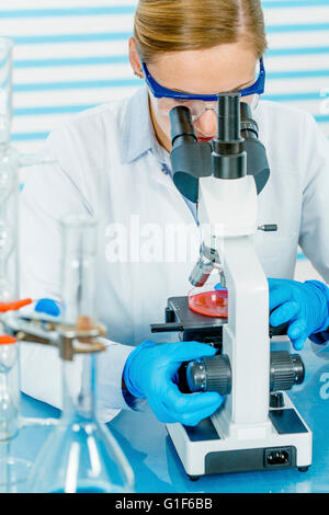 MODEL RELEASED. Female scientist using microscope in the laboratory. Stock Photo