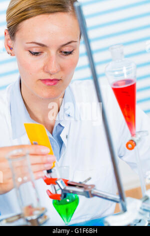 MODEL RELEASED. Female chemist working in laboratory. Stock Photo