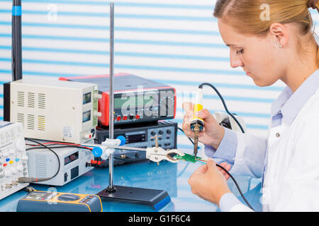MODEL RELEASED. Female technician working on circuit board. Stock Photo