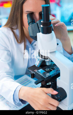 MODEL RELEASED. Female scientist using a microscope. Stock Photo