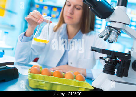 MODEL RELEASED. Female scientist testing egg yolk in a laboratory. Stock Photo