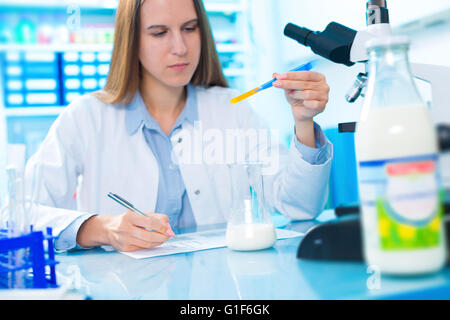 MODEL RELEASED. Female scientist testing milk sample. Stock Photo