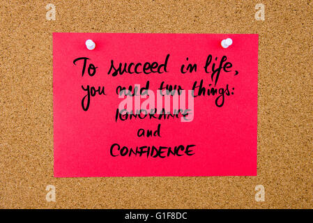 Red paper note with handwritten text To Succeed In Life You Need Two Things IGNORANCE and CONFIDENCE pinned on cork board with white thumbtacks Stock Photo