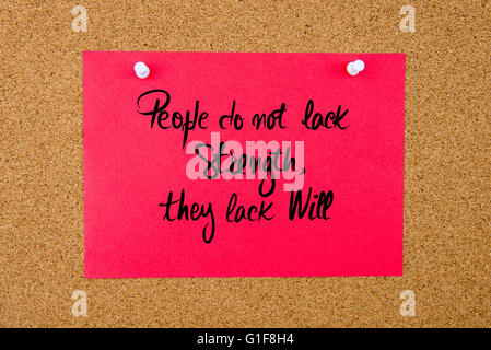 Red paper note with handwritten text People Do Not Lack Strength, They Lack Will pinned on cork board with white thumbtacks Stock Photo