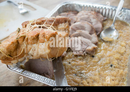 roast pork loin on a aluminum bowl with green apple sauce Stock Photo