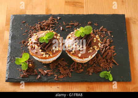 chocolate muffins with chopped nuts on wooden cutting board Stock Photo