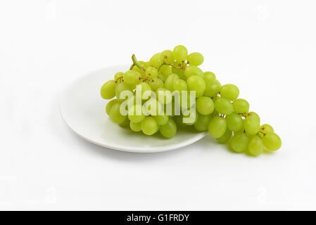 bunch of white grapes on white plate Stock Photo