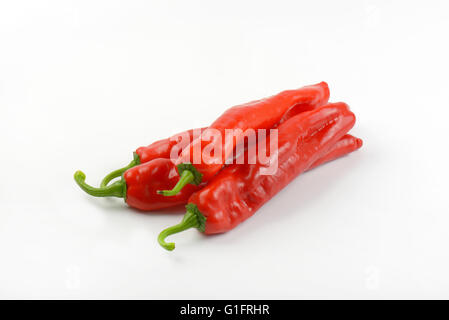 four red peppers on white background Stock Photo