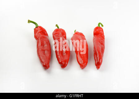 four red peppers on white background Stock Photo