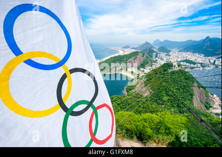 RIO DE JANEIRO - MARCH 10, 2016: Olympic flag hangs above a skyline view of the city from Pão de Açucar Sugarloaf Mountain. Stock Photo