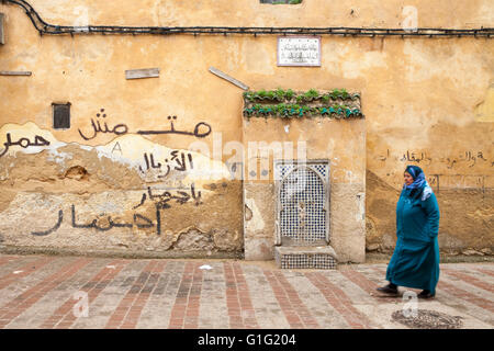 Woman walking along street in the medina, Fez Stock Photo