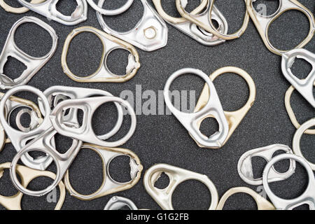Ring pull cans opener on black metallic background Stock Photo