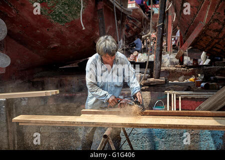 Carpenter working with wood using an electric wood plane power tool. Stock Photo
