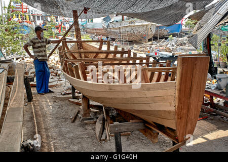 thai craftsman building a traditional wooden boat