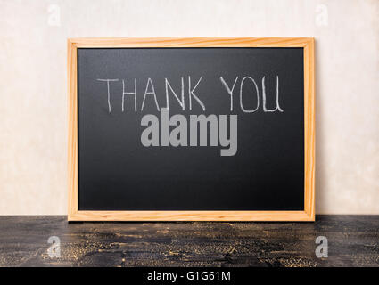 handwriting text thank you is written in chalkboard on craquelure black board, close up Stock Photo