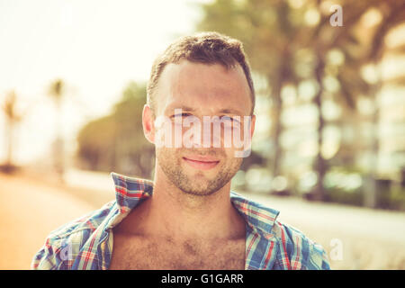 Young smiling handsome Caucasian man, outdoor portrait in sunny day Stock Photo