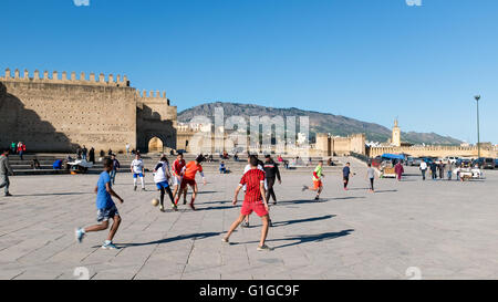 Boys playing football in a square of Fez, Morocco Stock Photo