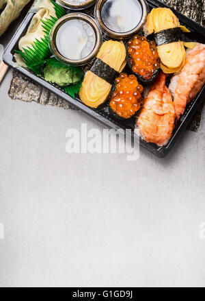 Sushi set with nigiri,  tamago egg , ama ebi raw prawn  and uni ikura on gray stone background, top view, place for text Stock Photo