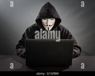Bełchatow, Poland - December 18, 2015: Man with the laptop wearing Vendetta mask - symbol for the online hacktivist group Anonym Stock Photo