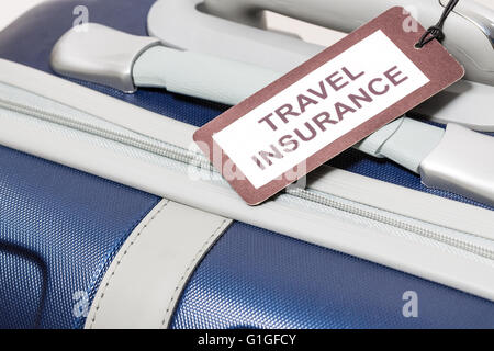 Travel insurance label tied to a suitcase. Stock Photo