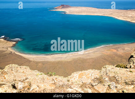 View over El Rio channel to southern tip Graciosa Island with sandy beach on  Lanzarote in foreground, Canary Islands, Spain Stock Photo