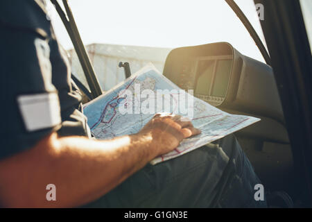 Close up shot of a helicopter pilot studying the flight route map while sitting in the cockpit of the aircraft. Pilot reading fl Stock Photo