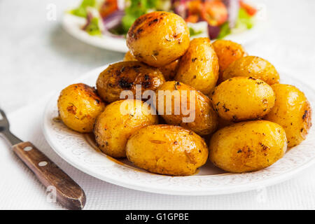 Young baked potatoes with green parsley Stock Photo