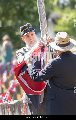 Charleston, USA. 14th May, 2016. Members of the Sons of the Confederacy during a flag raising ceremony during a memorial service at Magnolia Cemetery to mark Confederate Memorial Day May 14, 2016 in Charleston, South Carolina. The events marking southern Confederate heritage come nearly a year after the removal of the confederate flag from the capitol following the murder of nine people at the historic black Mother Emanuel AME Church. Credit:  Planetpix/Alamy Live News Stock Photo