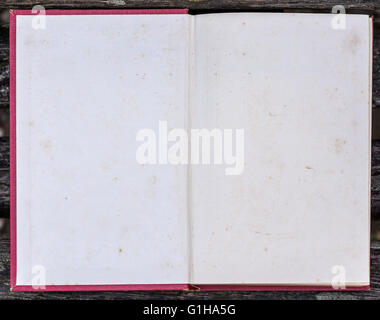 Old grunge book opened to the first page showing aged textured paper inside. Stock Photo