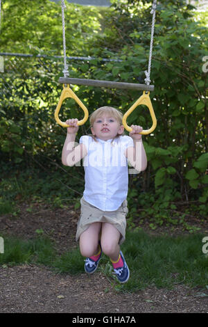 Girl hanging from monkey bars hi-res stock photography and images - Alamy