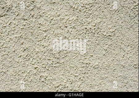Beige roughly wall texture. Decorative plaster facade of the building. Stock Photo