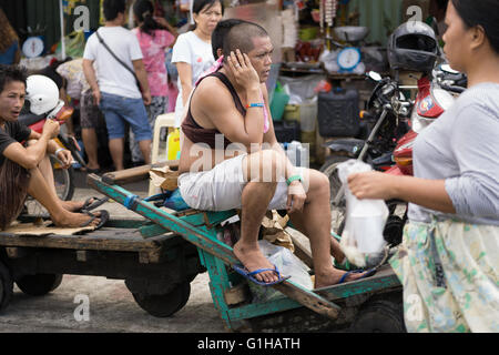 A man using his mobile phone in the Carbon Market located in Downtown Cebu City,Philippines Stock Photo