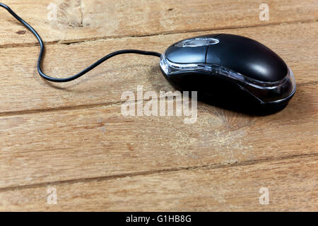 Black wired computer mouse on wood table Stock Photo