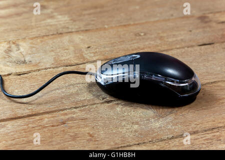 Black wired computer mouse on wood table Stock Photo