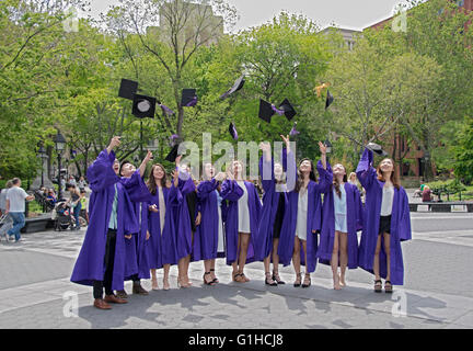 Asian NYU graduates throw their caps in the air for a graduation group photo in Washington Square Park in New York City Stock Photo