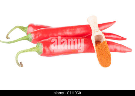 Pods of chili pepper and ground paprika in a wooden spoon Stock Photo