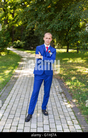 groom in a blue suit standing in the alley Stock Photo