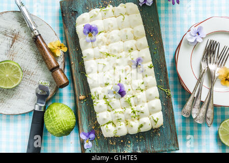 serving summer lime pie on kitchen table with flowers Stock Photo