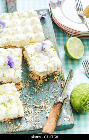 taste of summer, key lime pie with flowers, sliced and served on wooden board Stock Photo