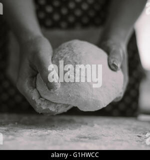 A woman kneads bread dough in her home kitchen. Stock Photo